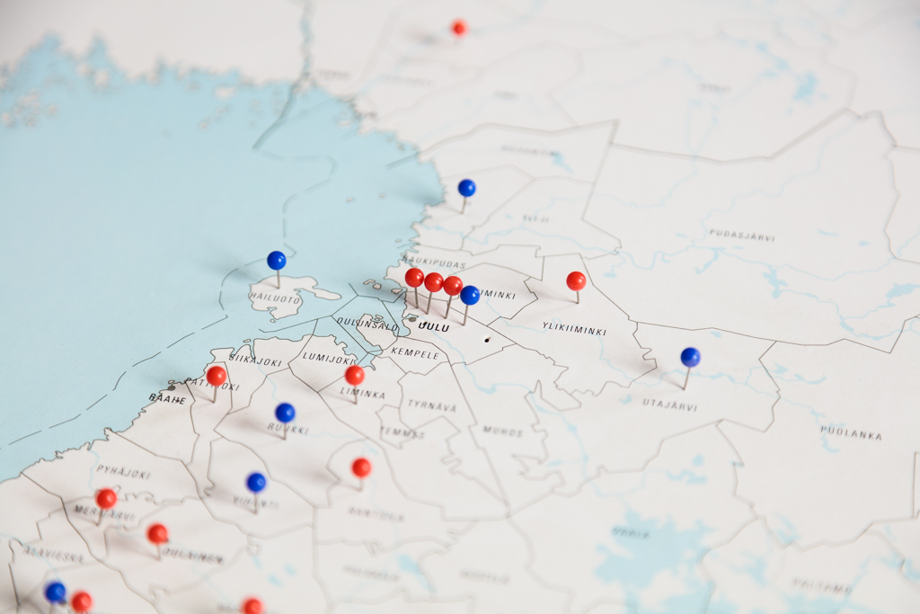 Lähikuva Suomen kartasta Oulun kohdalta, jossa sinisiä ja punaisia nuppineuloja.