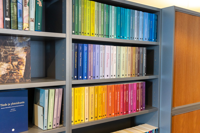 Kirjahylly, jossa on esillä SKS:n tiedesarjojen värikkäitä kirjoja.