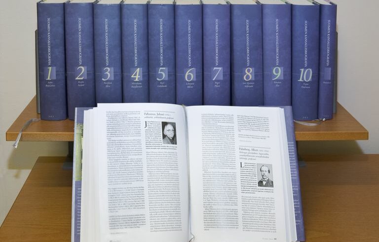 Kansallisbiografia-sarjan kirjat rivissä, joiden edessä yksi osa on avattuna.