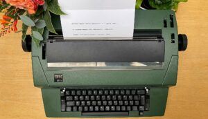 Vanha kirjoituskone, johon asetettu paperi.