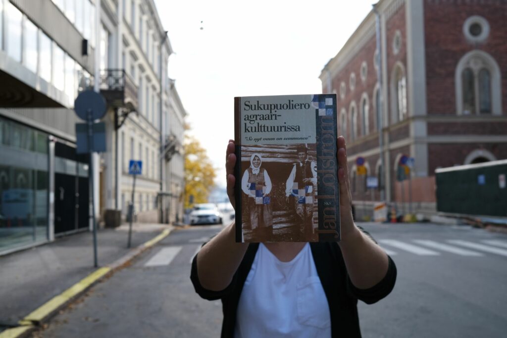 Ihminen pitelee kirjaa.